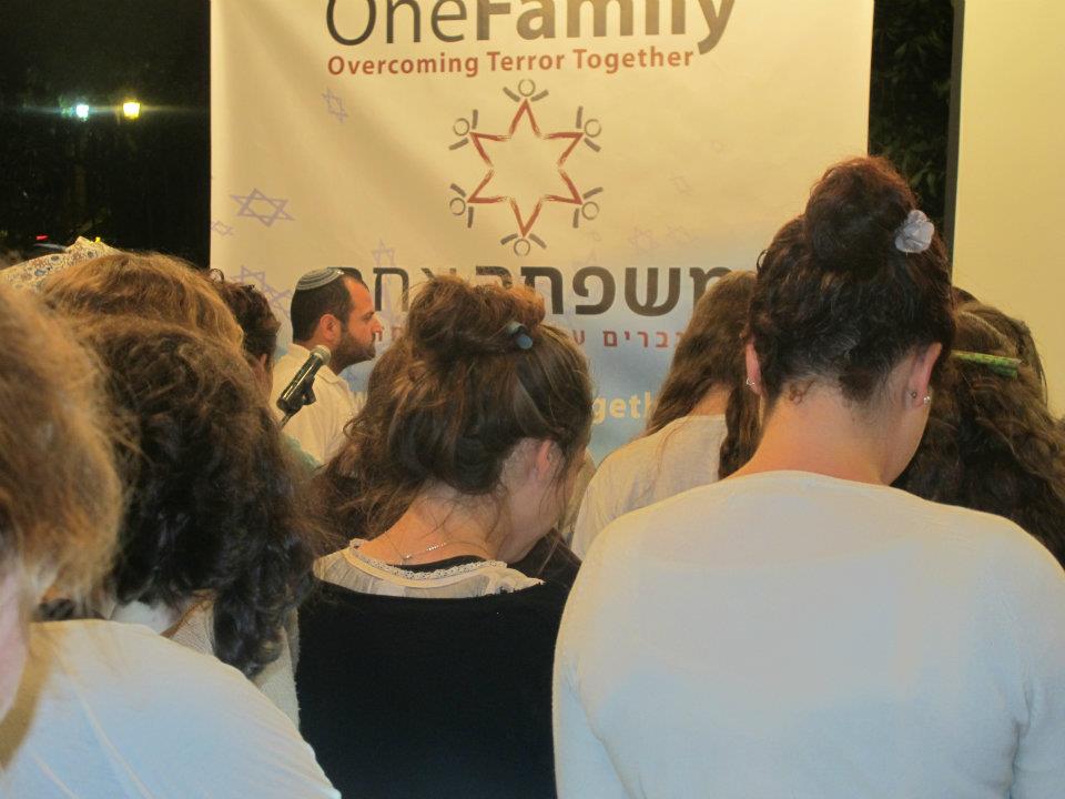 Participants in OneFamily's Yom Hazikaron event observe a minute of a silence