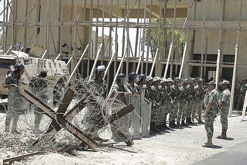 Egyptian soldiers preventing Palestinians from coming close to the iron gate of a Rafah border crossing with Egypt in the southern Gaza strip.
