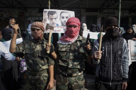 Masked Palestinians hold axes and a gun as they celebrate with others an attack on a Jerusalem synagogue, in Rafah in the southern Gaza Strip, on November 18, 2014. Two Palestinians armed with a meat cleaver and a gun killed four people in a the Bnei Torah synagogue in Jerusalem's Har Nof neighborhood on Tuesday before being shot dead by police. This was the deadliest attack in six years in the Jerusalem, and comes after a series of car-ramming and stabbing terror attacks in Israel.