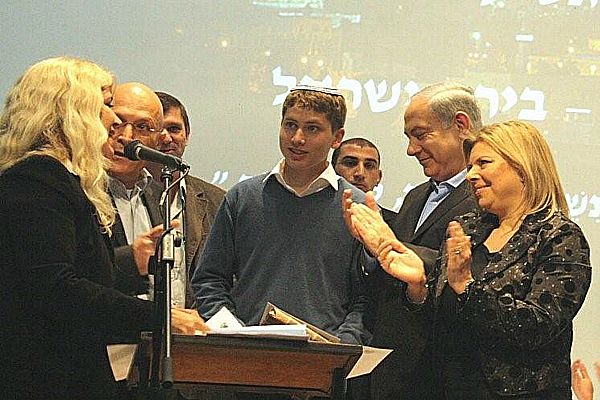 Avner-Netanyahu.ISRANET Sara and Prime Minister Benjamin Netanyahu flank their 15-year-old son, Avner, as he is named winner of the Jerusalem Bible Quiz. Photo Isranet