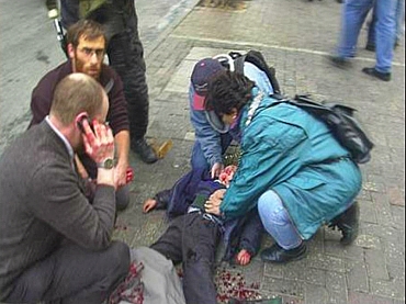 Alan Joseph Bauer stands over his son Yehonathon, minutes after they were injured in suicide bombing attack in Jerusalem on March 21, 2002.