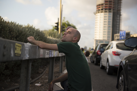 Israeli man tries for glimpse of Iron Dome rocket interception, July 15, 2014.
