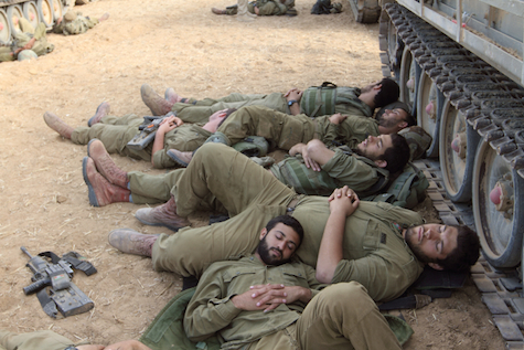 IDF soldiers rest while awaiting orders to enter Gaza