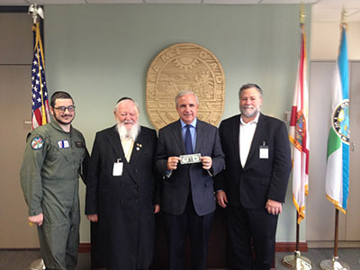 (L-R): Yitzie Rosenberg, Rabbi Pinchas Weberman, Miami-Dade County Mayor Carlos (holding dollar), and David Weberman 