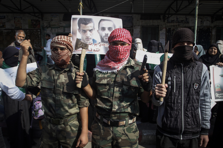 Masked Palestinians hold axes and a gun as they celebrate with others an attack on a Jerusalem synagogue, in Rafah in the southern Gaza Strip, on November 18, 2014. Two Palestinians armed with a meat cleaver and a gun killed four people in a the Bnei Torah synagogue in Jerusalem's Har Nof neighborhood on Tuesday before being shot dead by police. This was the deadliest attack in six years in the Jerusalem, and comes after a series of car-ramming and stabbing terror attacks in Israel.
