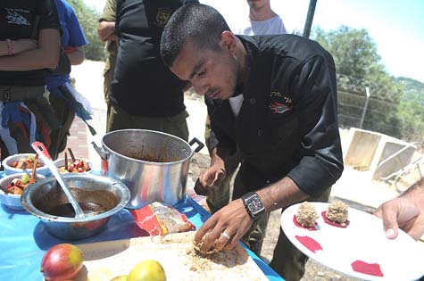 Combat Zone Cooking Competition: IDF base chef preparing and serving his unit's competition dish / Photo Credit: Gadi Yampel, IDF Spokeserson's Unit