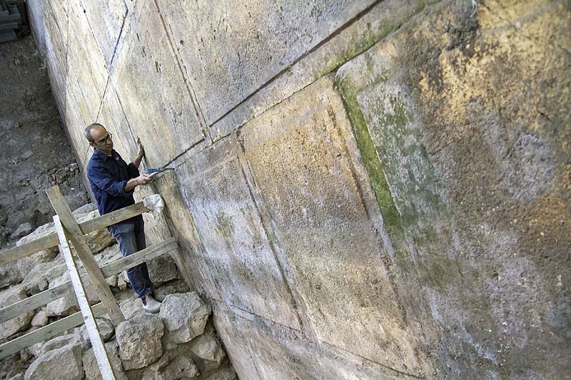 Israel Antiquities Authority archaeologist Dr. Joe Uziel near the Western Wall stones uncovered in the excavation. / Photo credit: Yaniv Berman, courtesy of the Israel Antiquities Authority