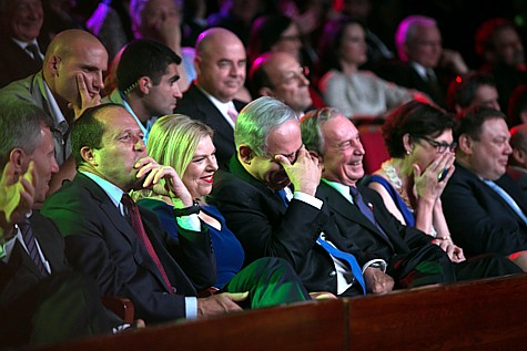 From left, Jerusalem mayor, Nir Barkat, Sara Netanyahu, Prime Minister Benjamin Netanyahu, and former New York mayor Michael Bloomberg, sit in the audience and laugh as American talk show host, Jay Leno (unseen), hosts the Genesis Award ceremony at the Jerusalem Theater, on Thursday, May 22, 2014. Former mayor of New York City, Michael Bloomberg, was given the award.