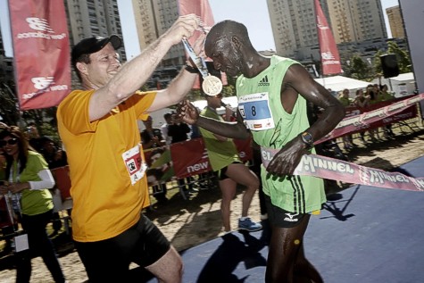 Jerusalem mayor Nir Barkat awarding the winner of the fourth international Jerusalem Marathon Ronald Kimeli Kurgat, at the finish line of the marathon.  Photo by Miriam Alster/ Flash90