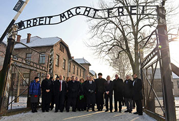 Knesset members walk through the entrance of Auschwitz.