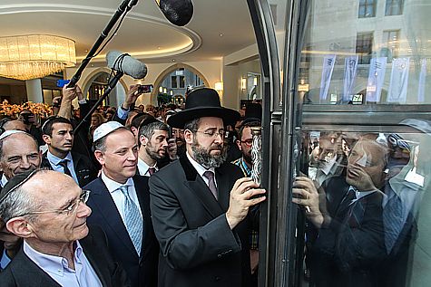 The Chief Rabbi placing the Mezuza on the entrance door of the Waldorf Astoria on opening day. Photo by Flash90