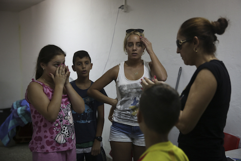 Ashkelon residents gather in bomb shelter, listen to explosions outside.
