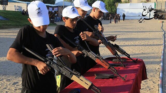 Palestinian boys learn how to assemble AK-47 assault rifles at a Hamas training camp, 2021