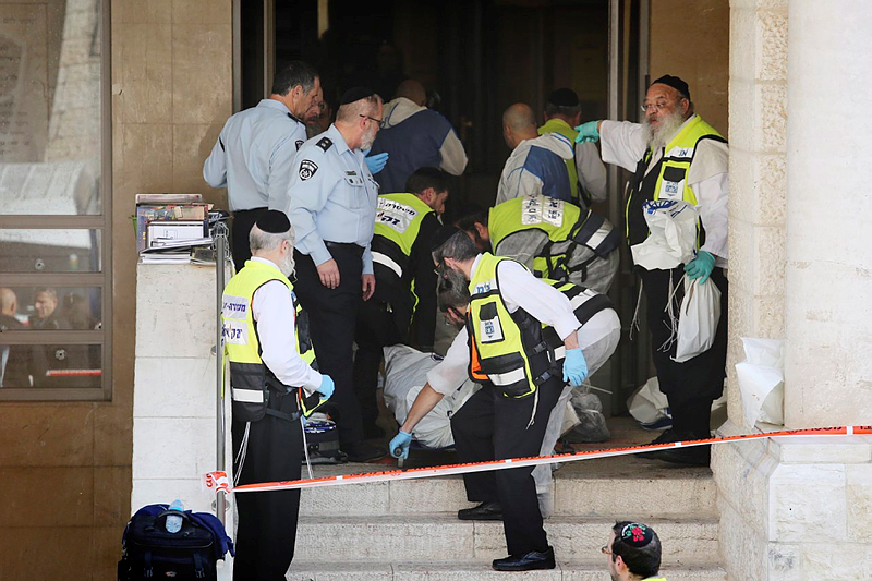 Police remove casualties from a Har Nof synagogue after two Jerusalem Arabs butchered four Jews to death.