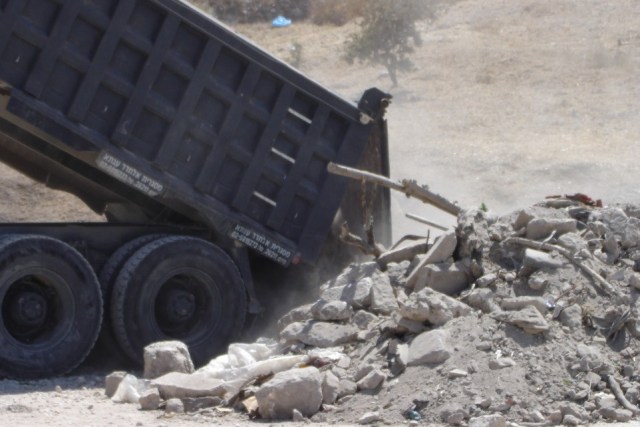 A truck unloads earth