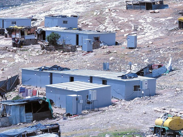 Blue EU signs affixed to homes and out-houses built illegally for an illegal Palestinian settlement