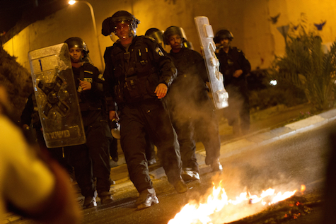 Israeli security forces take cover from stone-throwing Arabs in Umm el Fahm, , July 5, 2014.