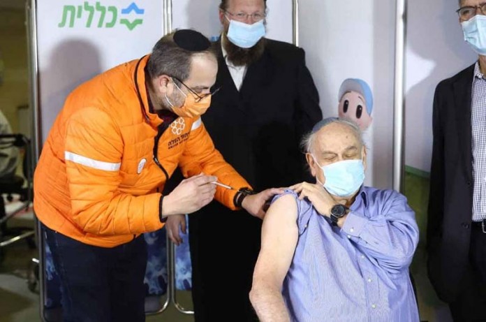 United Hatzalah founder Eli Beer vaccinating a patient, January, 2021.
